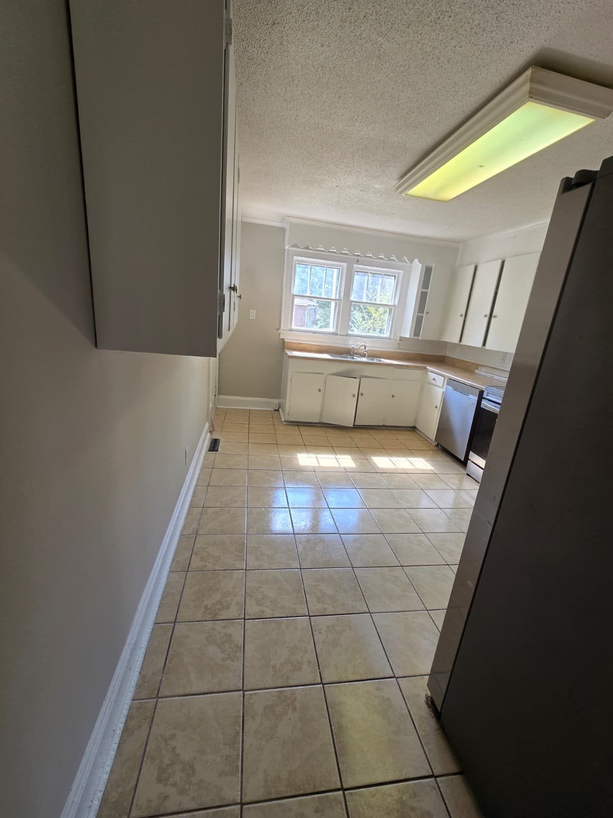 Kitchen with white cabinets and tile floor