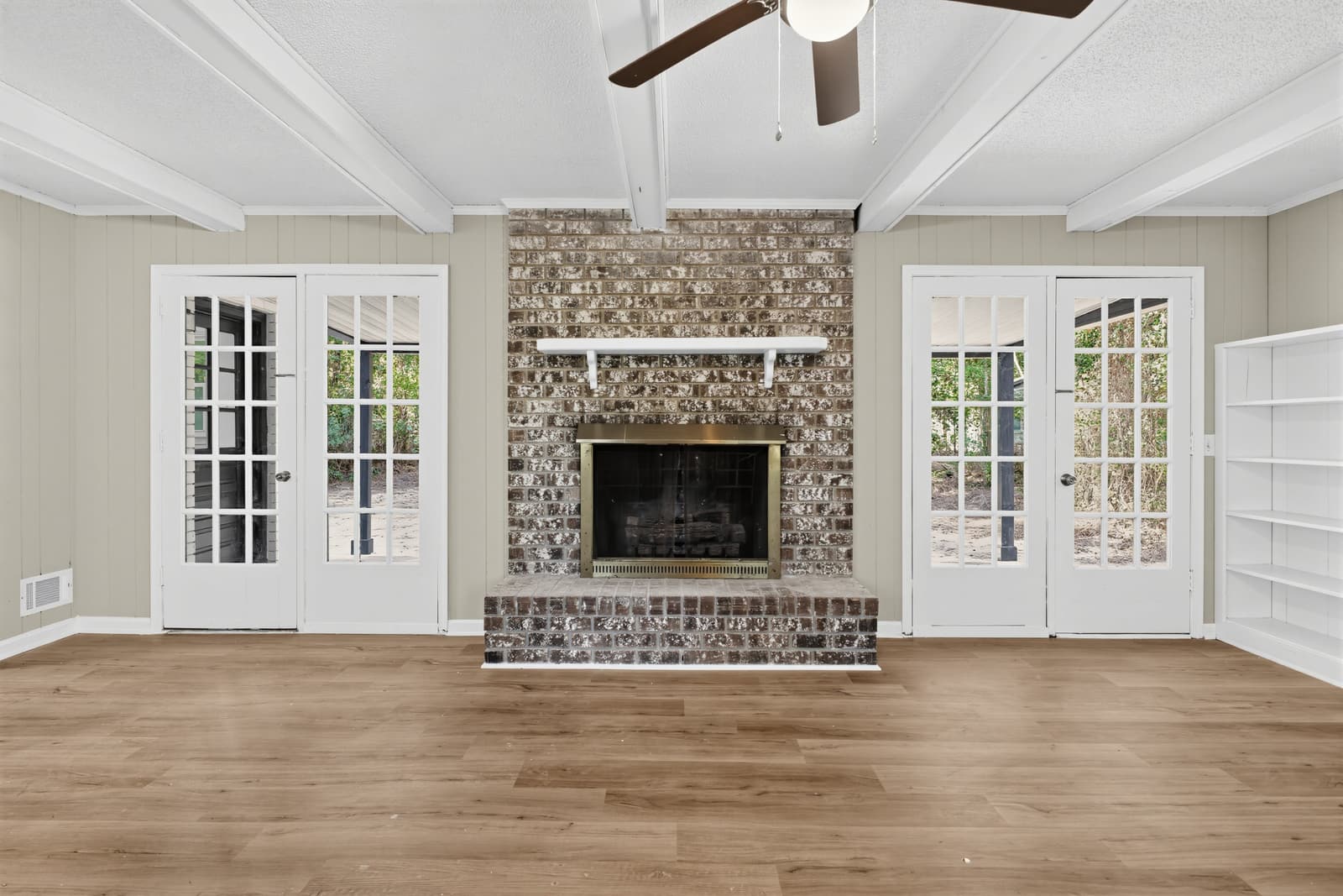 Living room with brick fireplace and French doors